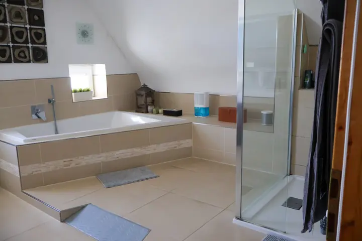 Upstairs bathroom with corner bathtub and glass shower under the sloped ceiling